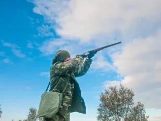 Un cazador eleva su arma hacia el cielo durante la temporada de caza en Navarra 2024/2025.