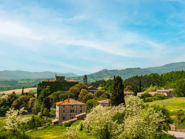 Casas rurales rodeadas de naturaleza con montañas al fondo.